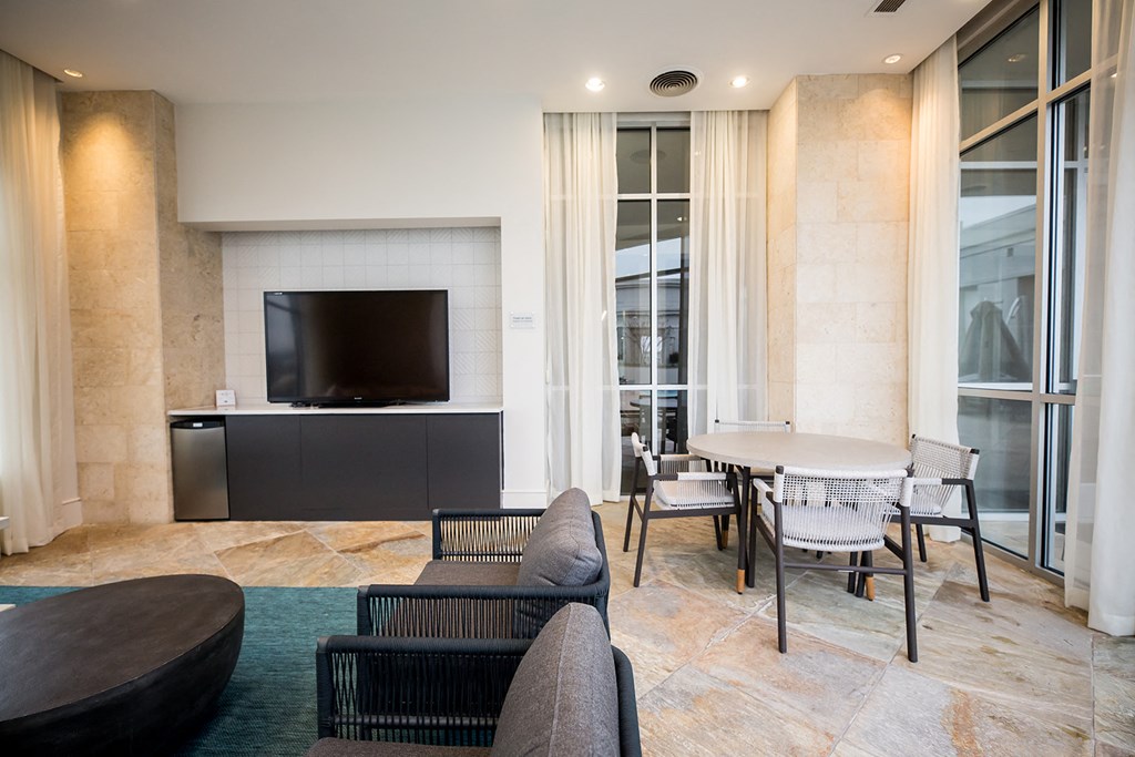 a room with a tv and a table and chairs