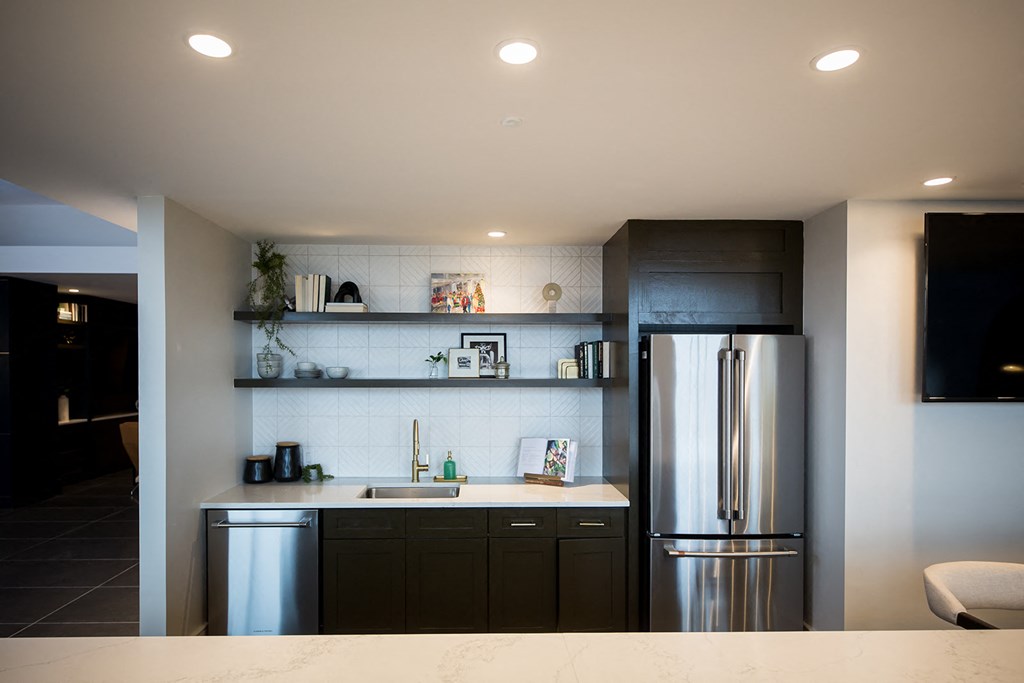 a kitchen with dark cabinets and stainless steel appliances