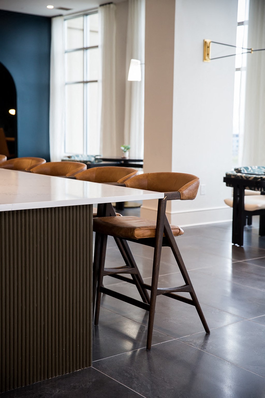 a bar with stools and a billiard table in a room with white walls and dark