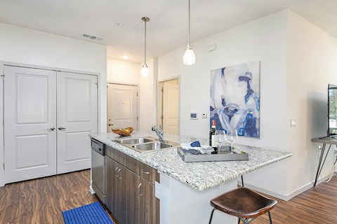A kitchen with a white counter top and a brown stool.