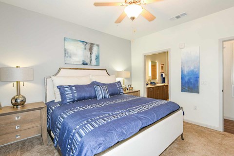 A bedroom with a large bed and a ceiling fan.