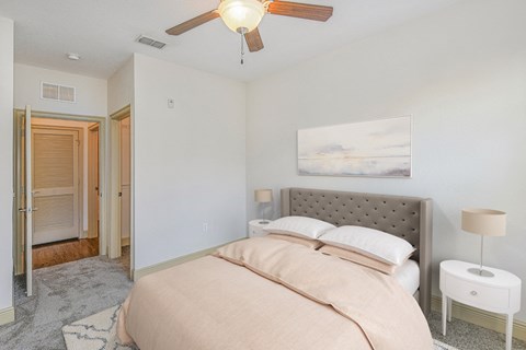 a bedroom with a bed and a ceiling fan