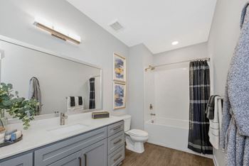 a bathroom with a large mirror and a toilet next to a bathtub