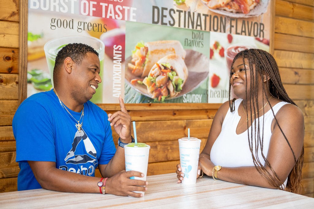 a man and a woman sitting at a table in a fast food restaurant