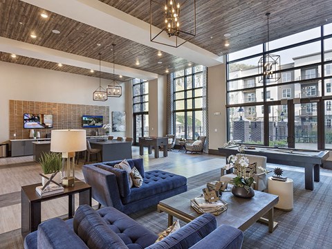 A modern living room with a blue couch and a wooden ceiling.