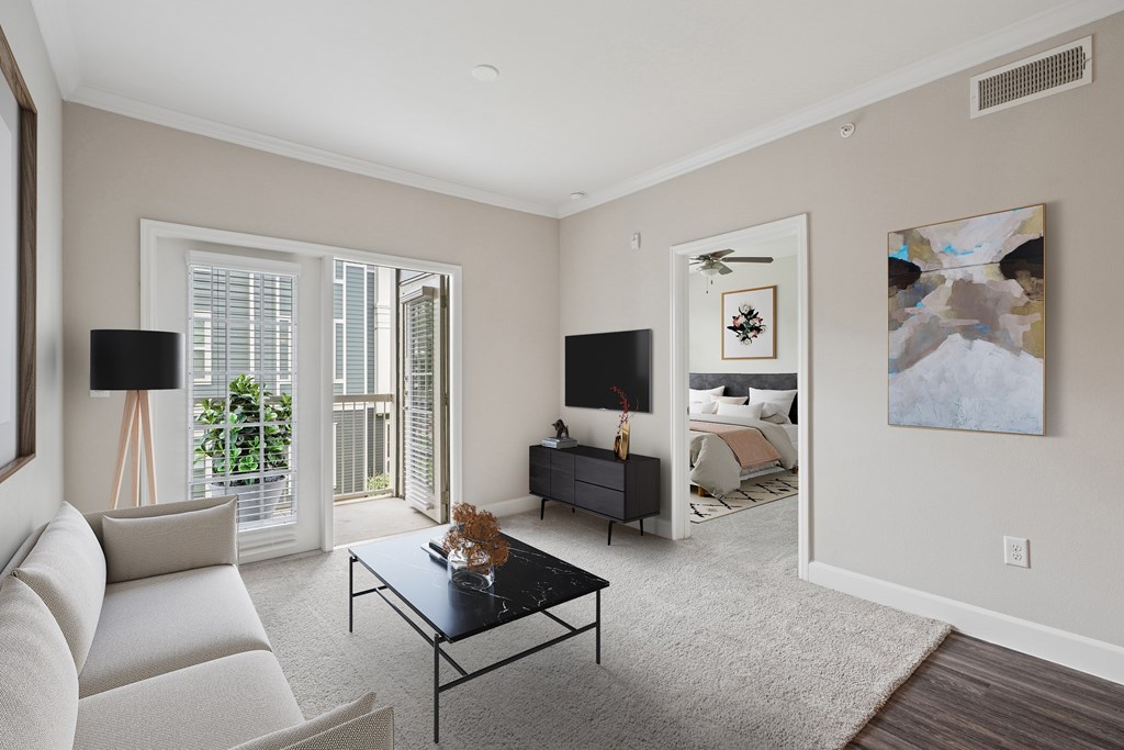 A living room with a white couch, a black coffee table, and a painting on the wall.