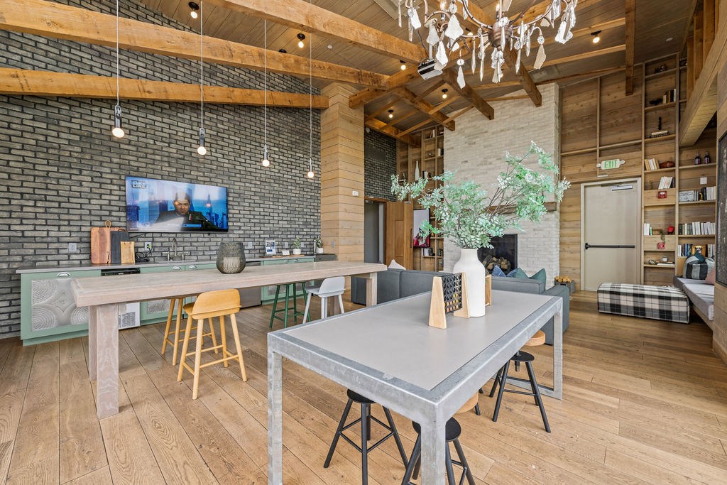 A modern dining area with a grey table and yellow chairs.