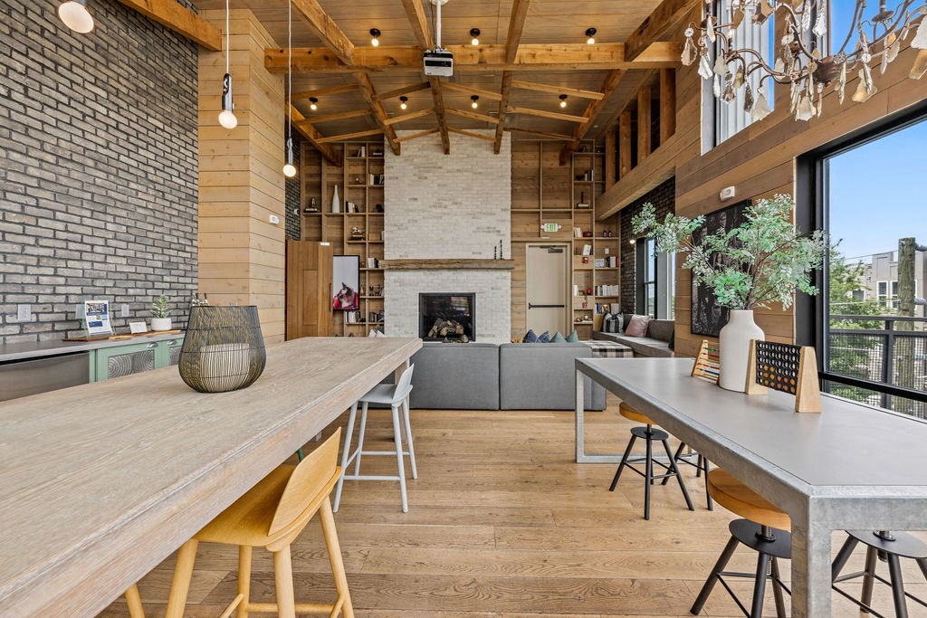 A modern kitchen with a long wooden table and chairs.