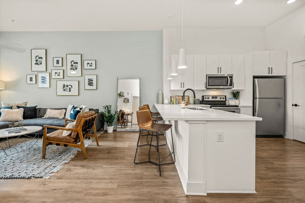 A modern kitchen with a white island and stainless steel appliances.