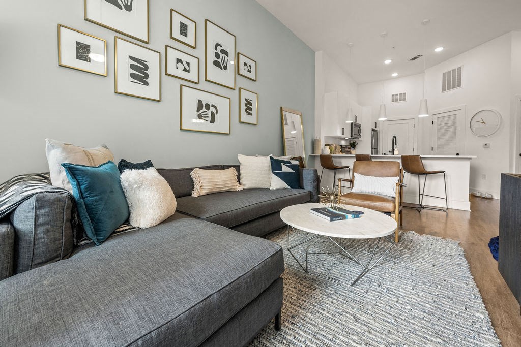 A living room with a grey couch and a white coffee table.