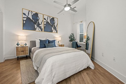 A bedroom with a large bed and a ceiling fan.