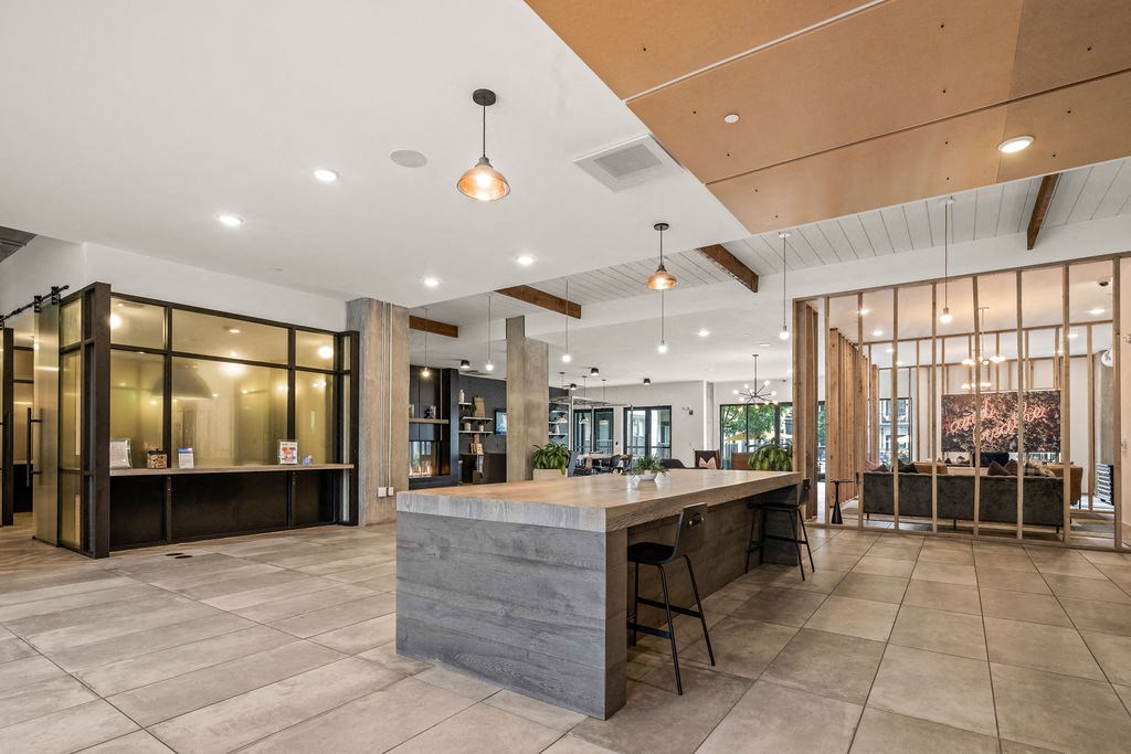A modern office lobby with a reception desk and a view of the outdoors.