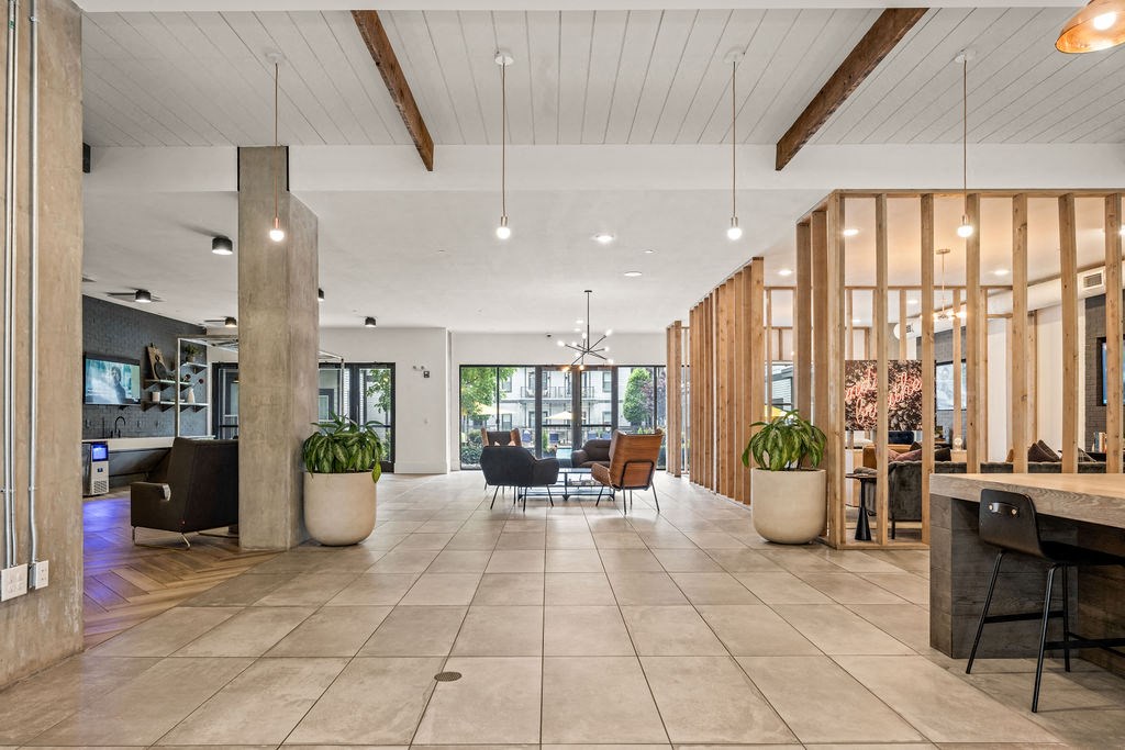A spacious interior with wooden beams and a tiled floor.