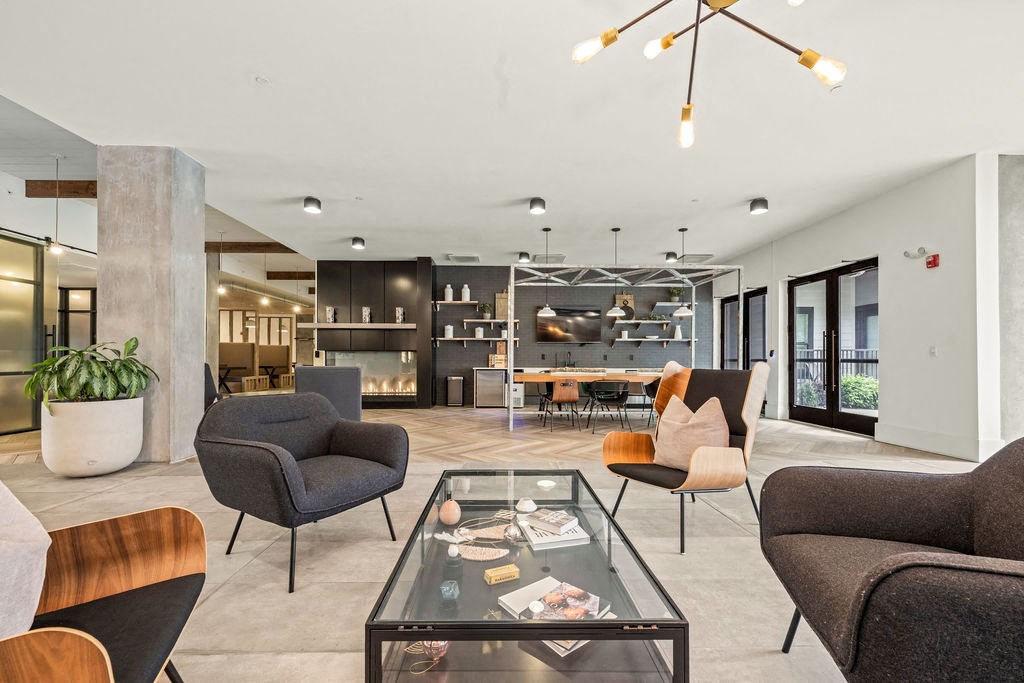 A modern living room with a glass coffee table and grey couches.