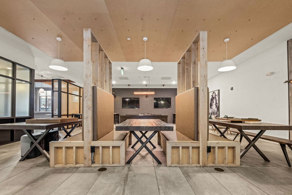 A modern dining area with wooden tables and benches.