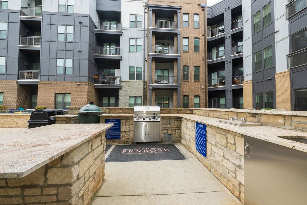 A trash can is located in the middle of a courtyard between two buildings.