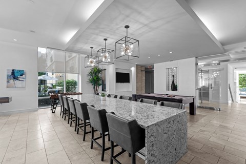 the dining room has a large granite counter top and a billiards table