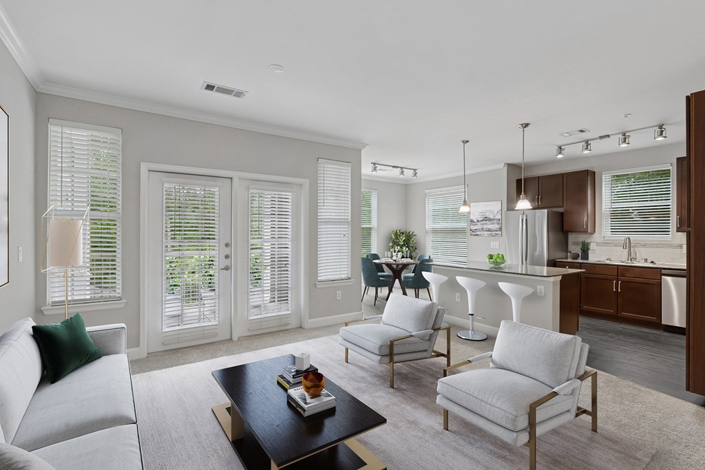 A modern living room with a grey sofa, a coffee table, and a dining area in the background.