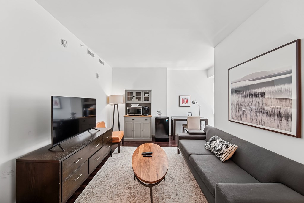 A living room with a grey couch and a television.