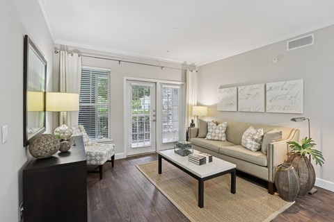 A living room with a couch, a coffee table, and a side table with a lamp.