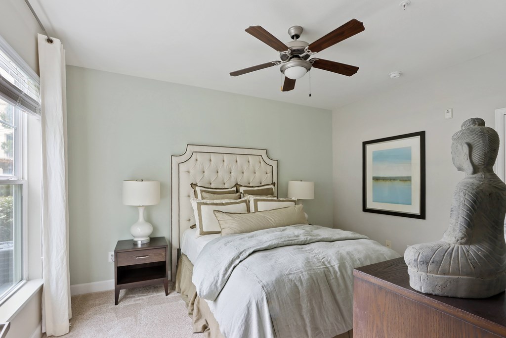 A bedroom with a large bed and a ceiling fan.