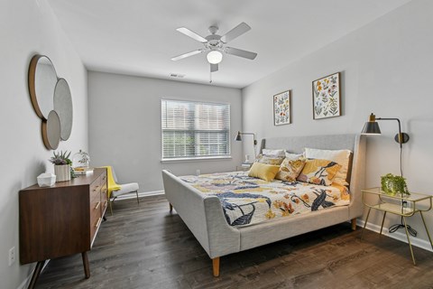 A bedroom with a bed, dresser, and mirror.