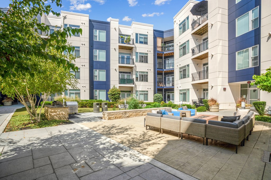 a patio with couches and a fire pit in front of an apartment building at Indigo 301 Apartments, Pennsylvania, 19406 at Indigo 301 Apartments, Pennsylvania, 19406