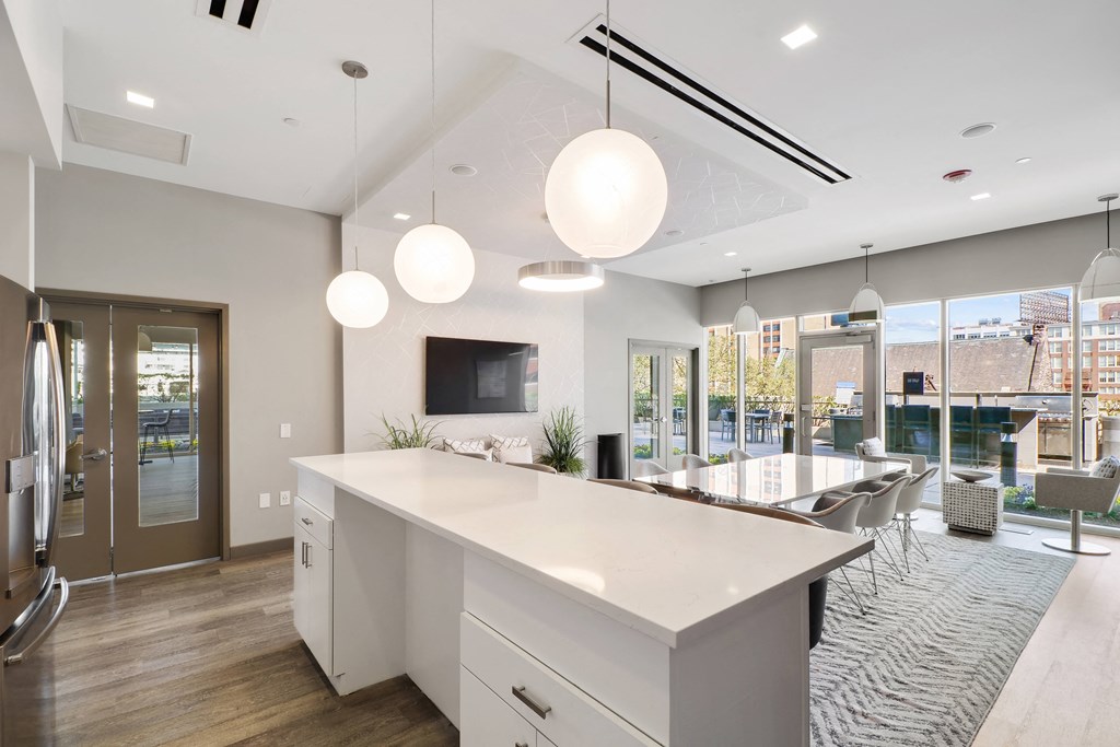 a kitchen with white countertops and a large center island with a breakfast bar