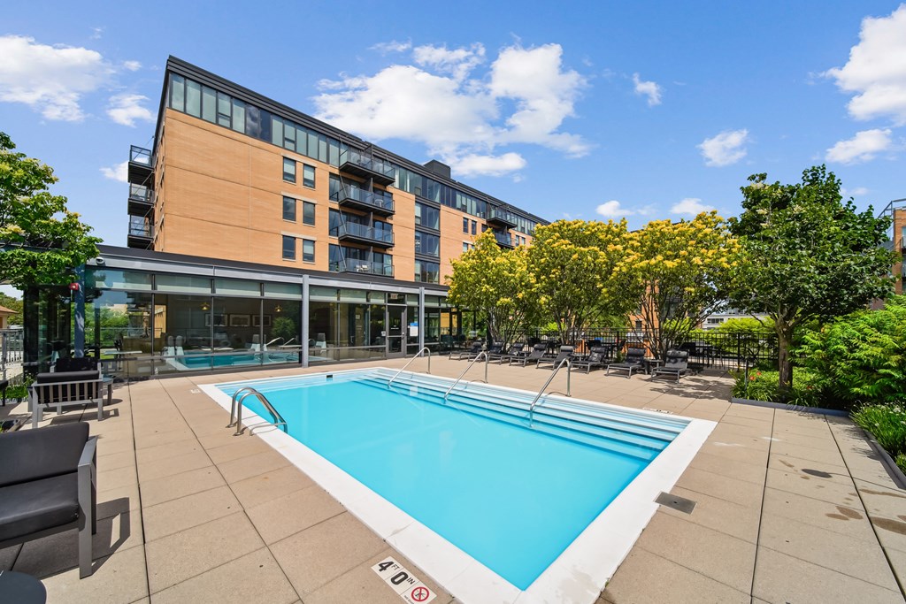 A swimming pool in a sunny outdoor pool area.