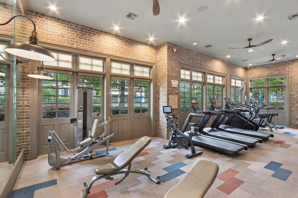 A gym with a brick wall and a variety of exercise equipment.