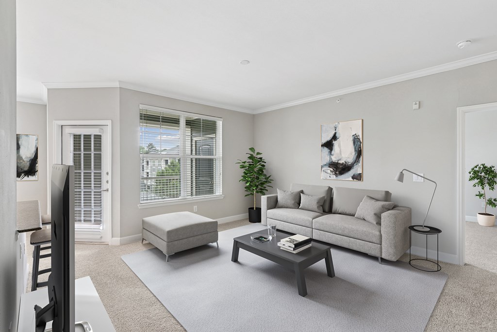 A living room with a grey couch, a white chair, and a coffee table.