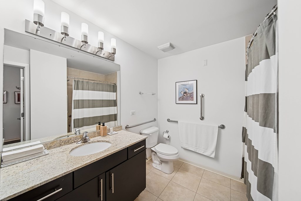 A bathroom with a sink, toilet, and a shower.