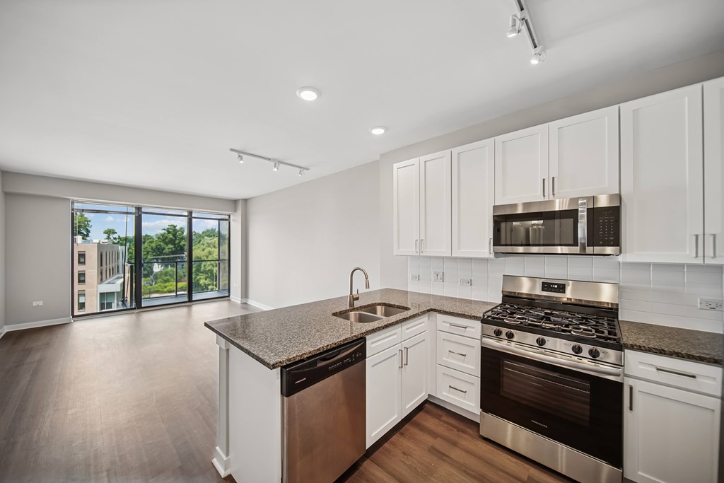 A modern kitchen with stainless steel appliances and white cabinets.