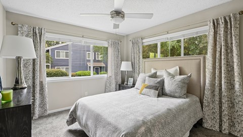 A bedroom with a large bed and a ceiling fan.