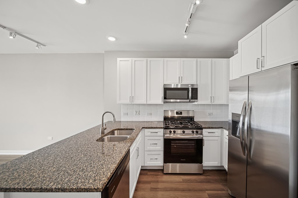 A modern kitchen with stainless steel appliances and white cabinets.