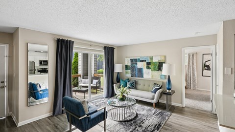 A living room with a blue chair and a white couch.