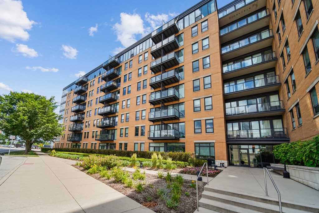 A modern apartment building with a walkway in front.