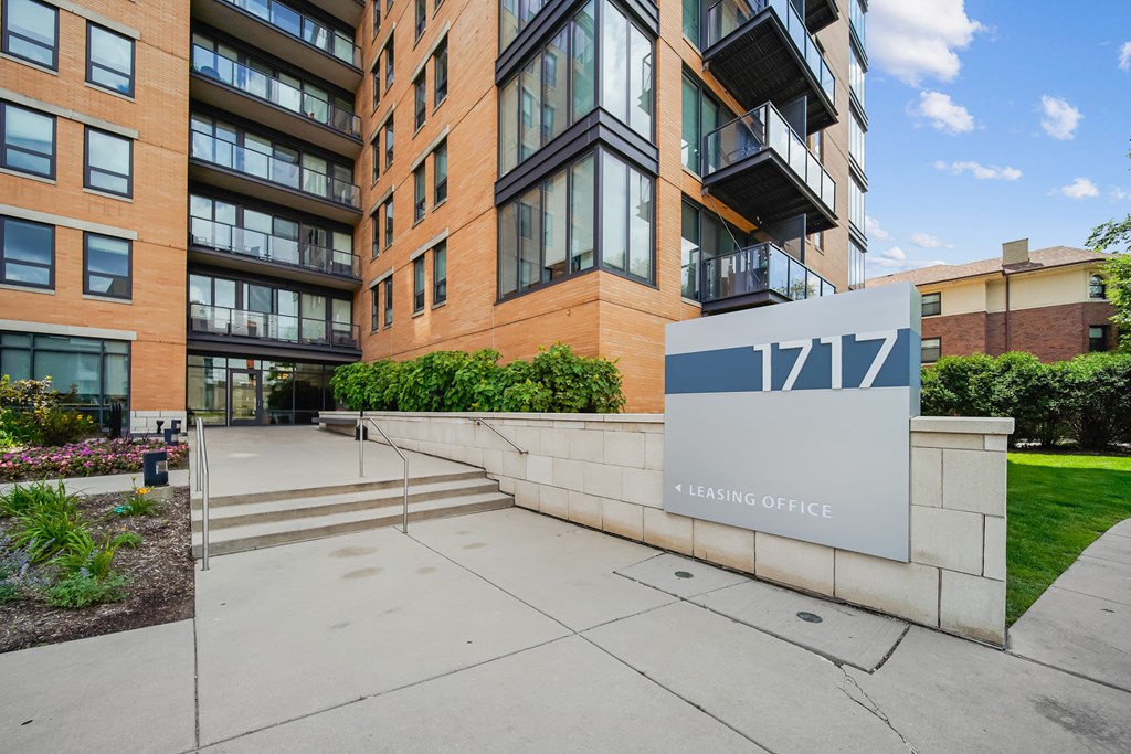 A modern building with a leasing office sign in front.