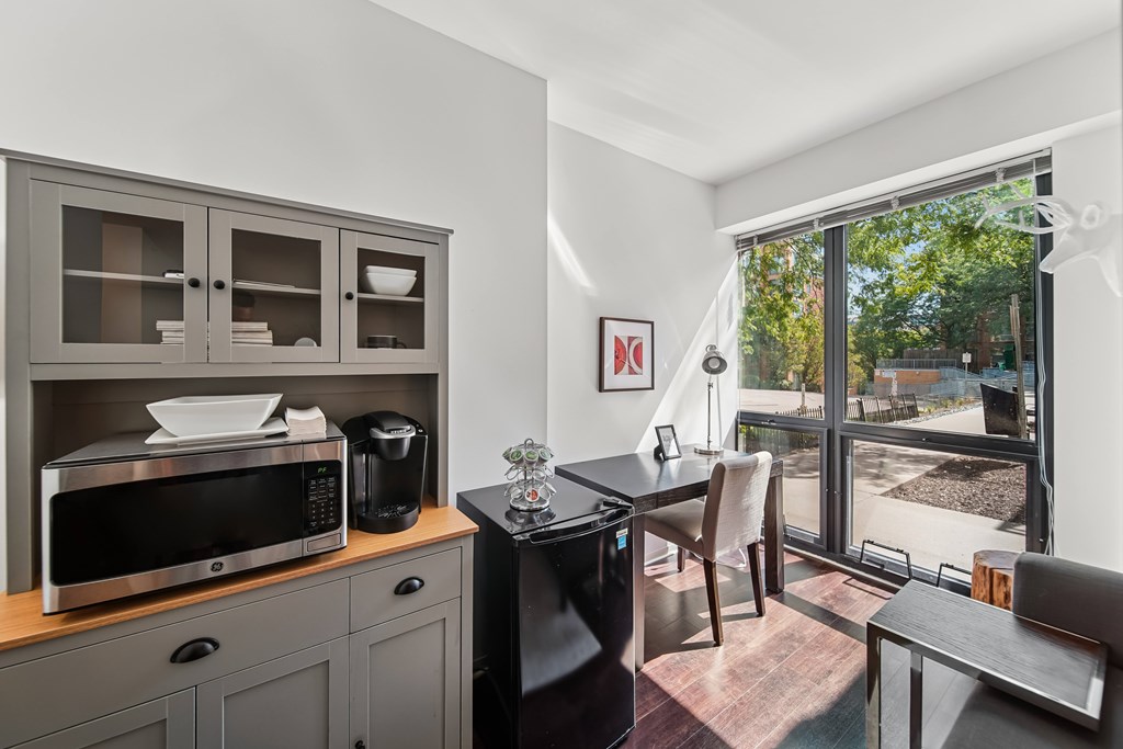 A kitchen with a microwave, oven, and a fridge.