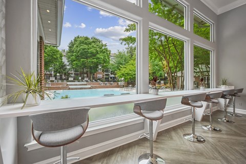 a dining room with a large window overlooking a pool