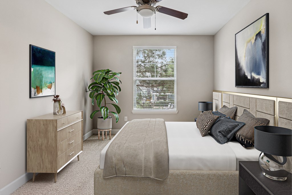 A bedroom with a bed, nightstand, and a painting on the wall.