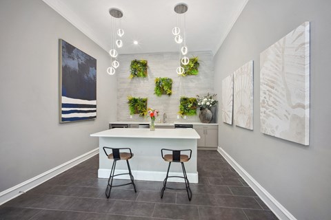 A kitchen with a white counter and two stools.