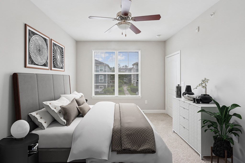 A bedroom with a large bed and a ceiling fan.