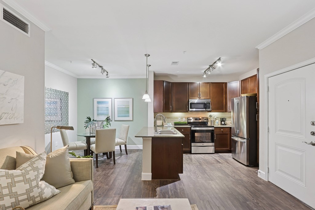 A modern kitchen with dark wood cabinets and stainless steel appliances.