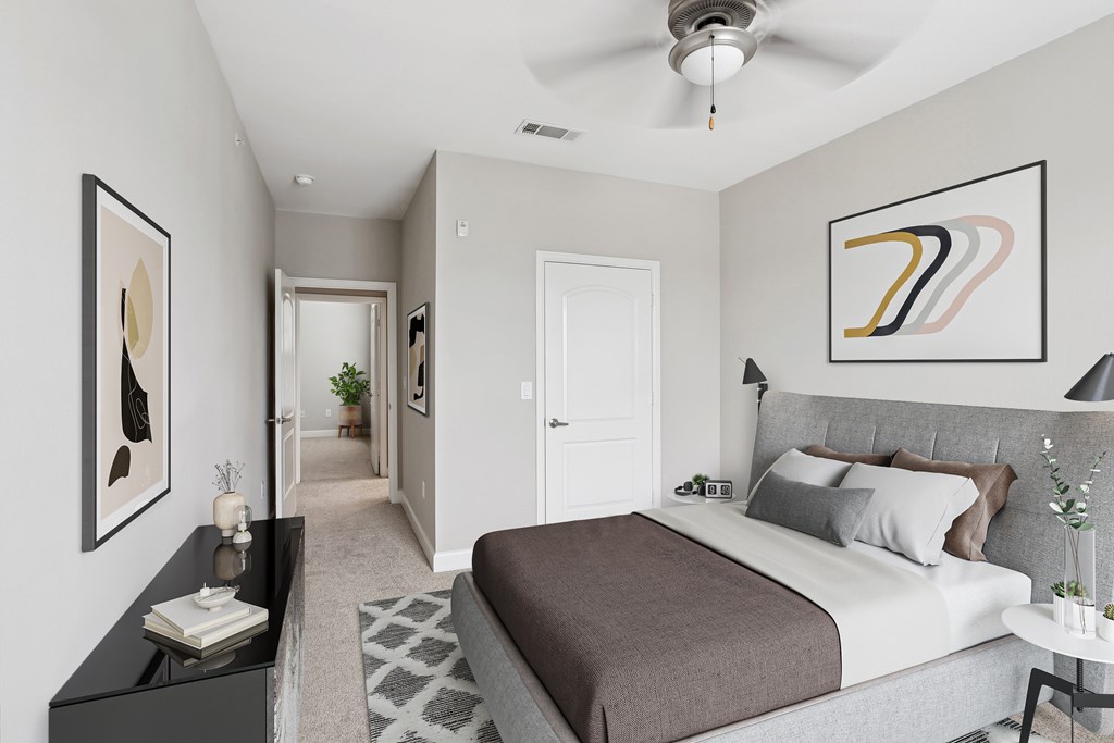 A bedroom with a large bed and a ceiling fan.