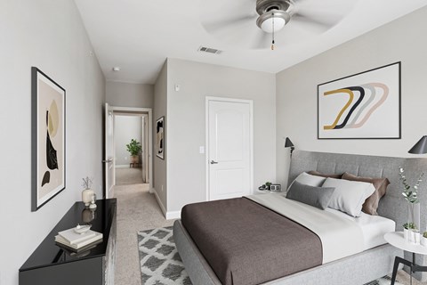 A bedroom with a large bed and a ceiling fan.