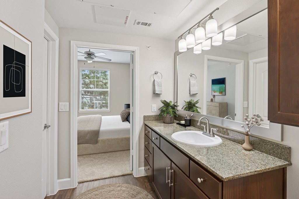 A bathroom with a sink, mirror, and a window.