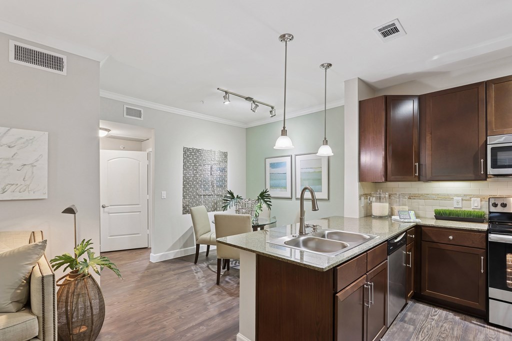 A kitchen with brown cabinets and a white counter.