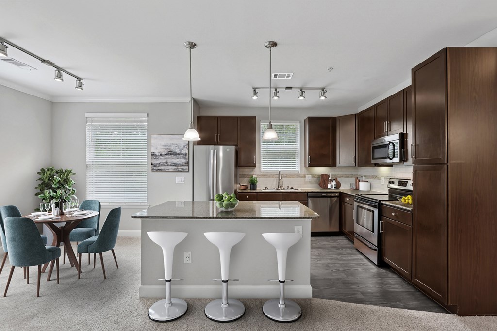 A kitchen with a table and chairs in front of it.