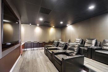 a large screening room with leather couches and a large screen tv